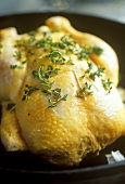 Chicken with herbs on black plate
