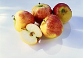 Äpfel mit Wassertropfen und Apfelhälfte