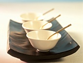 Asian food bowls on black tray