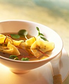 Wan tan soup with strips of chili and watercress
