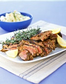 Lamb with rosemary and lemon wedges