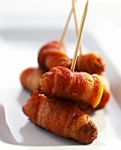 Sausages wrapped in bacon on cocktail sticks