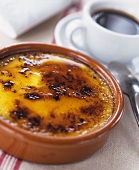 Catalan cream in terracotta bowl; coffee