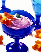 Water melon mousse in blue bowl with edible flowers