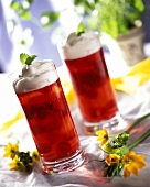 Raspberry jelly with cream in two glasses on table
