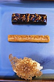 A chocolate bar, a stick of caramel and mousse topped with a caramel leaf