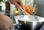 Stirring soup with whisk