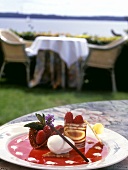 Raspberry dessert with ice cream on sun terrace of café