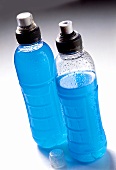 Pale-blue fitness drinks in sports bottles