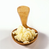 Cooked couscous on wooden spoon
