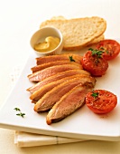 Duck breast with tomatoes, spicy sauce and bread