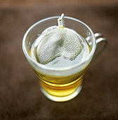 Grüner Tee in Glastasse mit Teesieb