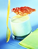 Pea soup in glass with fried rasher of bacon