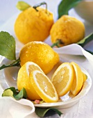 Fresh lemons with leaves in ceramic bowl