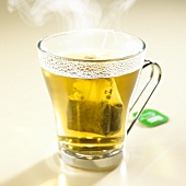 Steaming peppermint tea with tea bag in glass