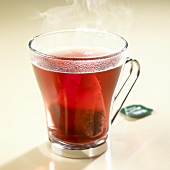 Hot fruit tea with tea bag in glass