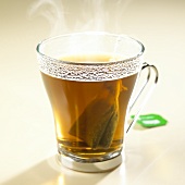 Steaming peppermint tea with tea bag in glass