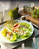 Romaine lettuce with raw ham, Roquefort, fruit and pine nuts