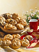 Crusty rolls in bread basket and on plate; butter; milk