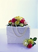 White wedding cake with roses and string of pearls