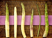 White and green asparagus spears on wicker tray