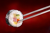 Maki-sushi with ham on chopsticks