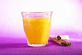 Glass of orange juice; cinnamon sticks