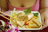 Woman with plate of Asian appetisers
