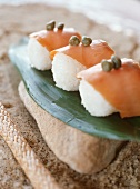 Sushi mit Lachs und Kapern auf Bananenblatt