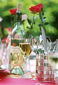 Sommerlicher Tisch im Garten mit Wein und Besteck