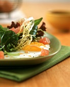 Salad leaves with fried egg and pink grapefruit
