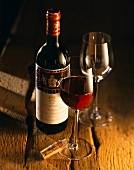 Bottle of 1994 Mouton Rothschild and two glasses on wooden table