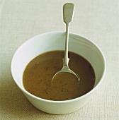 Dark brown gravy in white bowl
