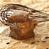 Pieces of chocolate in front of whisk