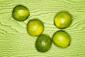 Limes on green wooden background