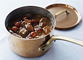 Duck curry with dates in copper pan