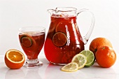 Jug and glass with sangria and citrus fruits