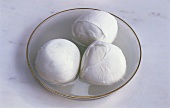 Three balls of mozzarella in a glass dish