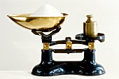 Old weighing scales with gilded pan, weight and sugar