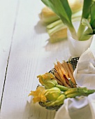Zucchiniblüten und Möhren auf Teller, Lauch in Schale