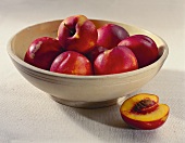 A Bowl of Nectarines; One Half Next to Bowl