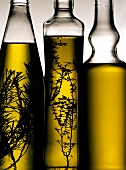 Three bottles of olive oil with rosemary and thyme