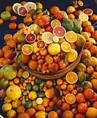 Whole and half citrus fruits in and beside basket 