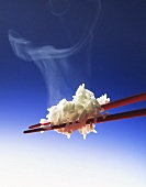 Steaming rice on red chopsticks