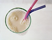 A glass of milk with two drinking straws