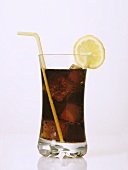 A glass of Cola with ice cubes, slice of lemon and straw