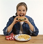 Model eating hamburger with chips