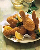 Deep-fried chicken pieces with parsley and lemon segments