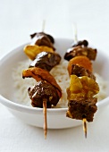 Two beef and vegetable kebabs on rice