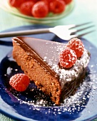 A piece of moist chocolate cake with raspberries